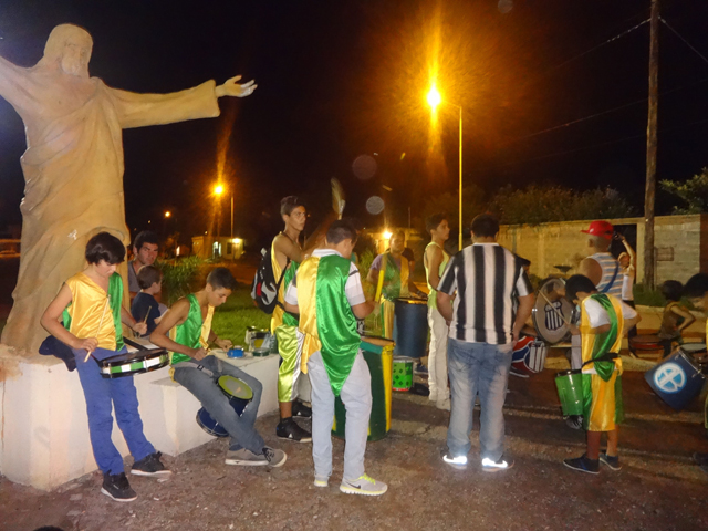 Los intérpretes de la comparsa Color y Alegría ajustan sus instrumentos junto a la réplica del Cristo Redentor. Crédito: Fabiana Frayssinet/IPS.