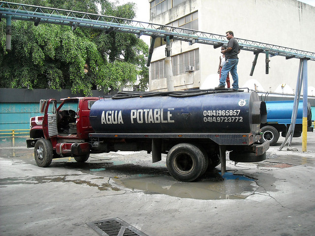 Un camión cisterna se carga de agua en el barrio de El Paraíso, suroeste de Caracas, para después venderla en barrios pobres o edificios de clase media a los que el recurso no llega. Crédito: Raúl Límaco/IPS