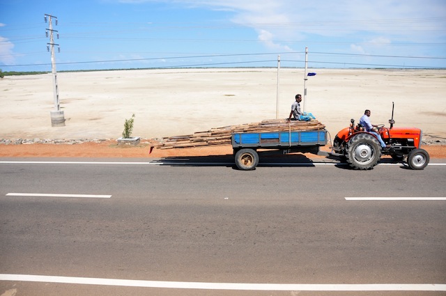 Un tractor avanza por la calzada seca al costado de una carretera sobre un terraplén en el norteño distrito de Kilinochchi. Funcionarios consultados por IPS dijeron que la zona necesita nueve millones de rupias (unos 69.000 dólares) por semana de asistencia a causa de la sequía. Crédito: Amantha Perera/IPS.
