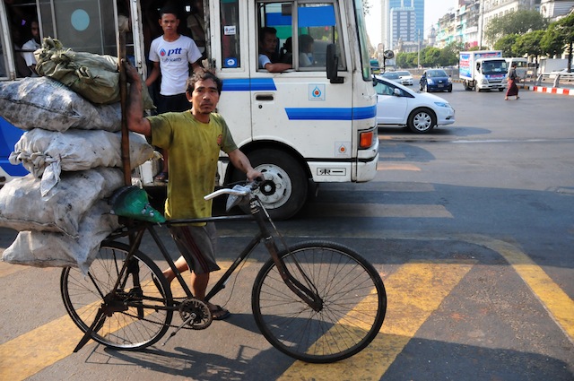 Un hombre empuja su bicicleta carga basura por las calles de Yangón. A pesar del rápido crecimiento económico, las disparidades parecen ampliarse, con 10 por ciento de la población que concentra 35 por ciento de la riqueza de Myanmar. Crédito: Amantha Perera/IPS