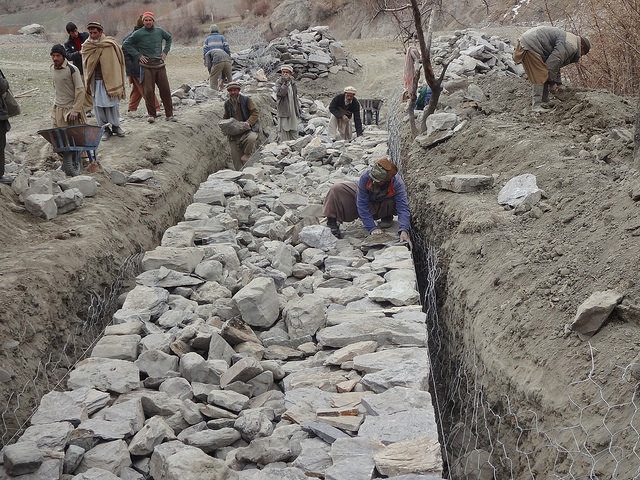 Obreros construyen muros de contención para controlar inundaciones en el norteño valle pakistaní de Bindo Gol. Crédito: Saleem Shaikh/IPS