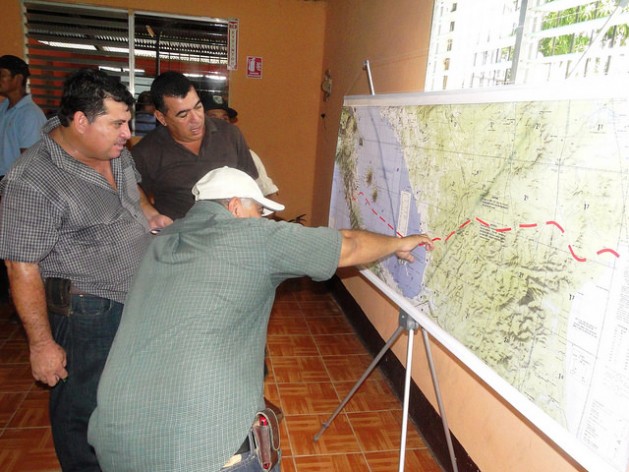 Tres agricultores analizan el trazado del Gran Canal Interoceánico sobre el mapa de Nicaragua, que la empresa china HKND Group presentó en la sureña ciudad de Rivas, durante uno de los encuentros que el consorcio ha organizado por todo el país con afectados por la gigantesca obra. Crédito: José Adán Silva/IPS