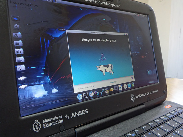 Una computadora portátil de las que se entregan a todo el alumnado de educación secundaria pública en Argentina. En la pantalla la imagen de una vaca volando, símbolo del sistema operativa Huayra, basado en el sistema libre Linus y creado localmente para el programa gubernamental Conectar Igualdad. Crédito: Fabiana Frayssinet/IPS