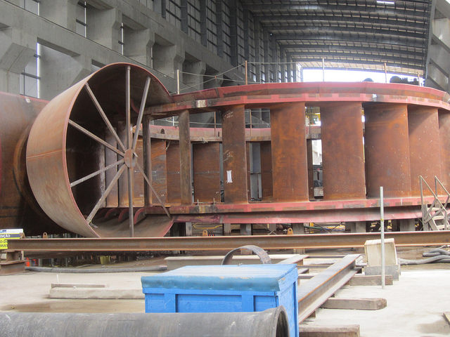 Componente de una de las 18 grandes turbinas que generarán electricidad en la planta principal de la central de Belo Monte, listo para ser introducido en uno de los grandes huecos circulares de metal construidos en la gigantesca obra en la Amazonia de Brasil. Crédito: Mario Osava/IPS