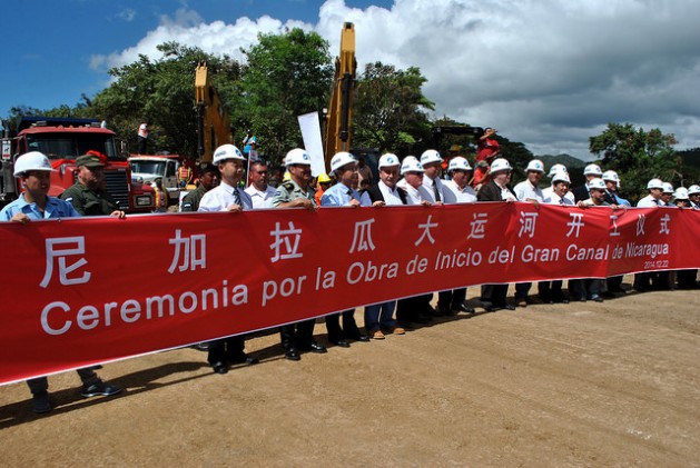 Ejecutivos de la empresa china HKDN-Group detrás de una gran pancarta, el 22 de diciembre de 2014, en la localidad de Brito Rivas, en la costa del océano Pacífico, en el acto de comienzo formal de la gigantesca obra del Gran Canal de Nicaragua, que partirá en dos el país. Crédito: Mario Moncada/IPS