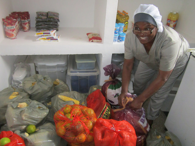La cocinera Penha Maria Flausina abre los sacos recién entregados por agricultores familiares, con frutas y hortalizas, en la Escuela Municipal João Baptista Cáffaro, con 500 alumnos de enseñanza primaria, en un barrio carenciado de la ciudad de Itaboraí, en el sureste de Brasil. Crédito: Mario Osava/IPS