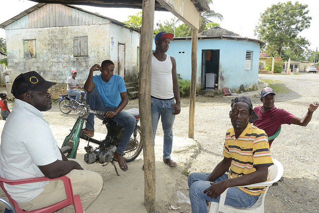 Hombres que conversan posan para mostrar el pueblo, donde predominan las personas haitianas y dominico-haitianas. Crédito: Dionny Matos.