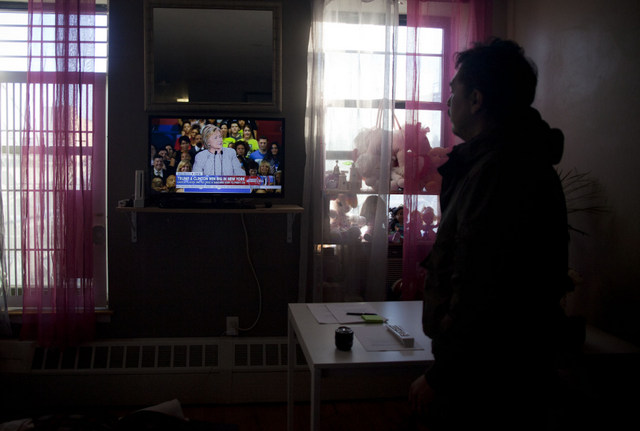 Un hombre observa una declaración de la aspirante demócrata, Hillary Clinton, en un televisor, en un pequeño local de un inmigrante latino, en Nueva York. Crédito: Mónica González/Pie de Página