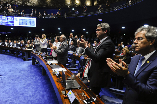 Un grupo de fatigados senadores aplaude al final de la maratónica sesión que decidió la separación inmediata de la presidenta Dilma Rousseff de sus funciones, mientras el Senado, convertido en tribunal, establece en un juicio político si hay razones para su casi segura destitución. Crédito: Marcos Oliveira/Agência Senado