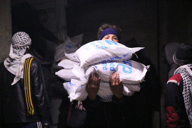 En la ciudad de Madaya, Siria, integrantes de la comunidad ayudan a descargar y distribuir la asistencia humanitaria. Crédito: WFP/Hussam Al Saleh.