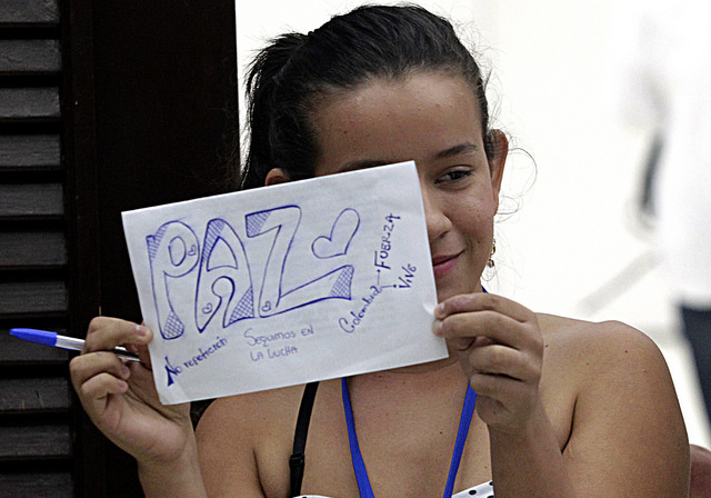 Erika Paola Jaimes, una de las víctimas del conflicto armado de Colombia, sostiene un cartel alusivo a la paz, durante su viaje a La Habana para participar en los diálogos de paz entre el gobierno y la guerrilla de las FARC, que viven su etapa culminante en la capital de Cuba. Crédito: Jorge Luis Baños/IPS
