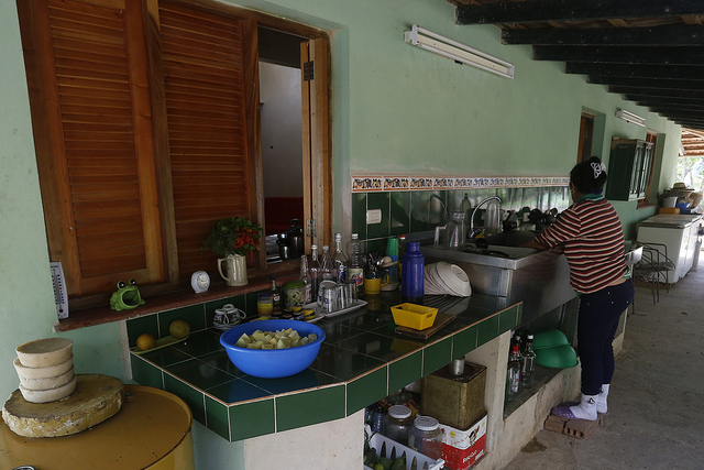 Una empleada doméstica lava algunos utensilios en la  Finca Marta, en el municipio de Caimito, en la occidental provincia de Artemisa, en Cuba. El trabajo en el servicio doméstico, por mucho tiempo casi desaparecido en el país, se ha extendido también a las zonas rurales. Crédito: Jorge Luis Baños/IPS