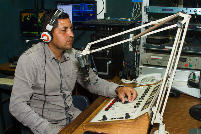 Wilfredo Hernández durante la transmisión de uno de los noticieros radiales de Izcanal Radio Y Televisión, un proyecto surgido en 2003 en Nueva Granada, en el oriente de El Salvador. La emisora comunitaria fue la única que se expandió con un canal de televisión. Crédito: Edgardo Ayala/IPS