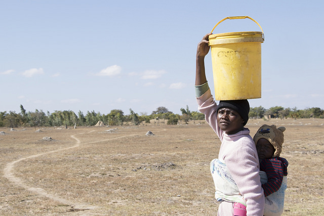Charity Ncube, de la localidad rural de Masvingo, en el sudeste de Zimbabwe, lleva a su hijo y un contenedor de 20 litros de agua. Crédito: Sally Nyakanyanga / IPS