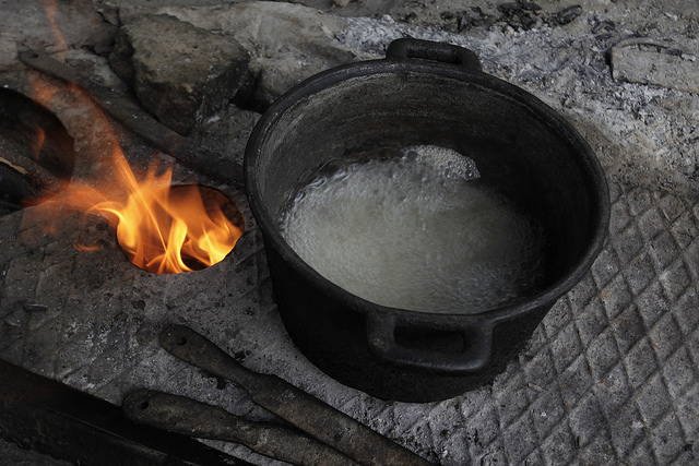 Unas 100.000 familias, mayormente rurales, usan aún leña para cocinar alimentos y otros usos domésticos, en fogones como en este donde hierve agua, en el hogar de Isabel Laurencio y Dagoberto Herrera, en Blanquizal de la Güira, en el oriente de Cuba. Crédito: Jorge Luis Baños/IPS