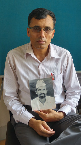 Suman Adhikari, presidente de la Plataforma Común de Víctimas del Conflicto de Nepal, muestra una fotografía de su padre asesinado en 2002. Crédito: Marty Logan/IPS.