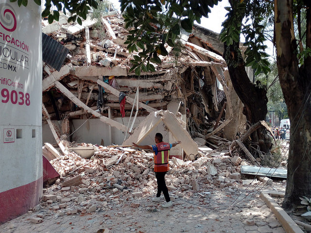 Un rescatista trata de asegurar el perímetro de un edificio caído el 19 de septiembre por el sismo de 7,1 grados, para evitar que alguno de sus antiguos residentes intente penetrar en sus ruinas, como ha sucedido en muchos de los edificios colapsados por el terremoto en Ciudad de México. Crédito: Emilio Gody/IPS