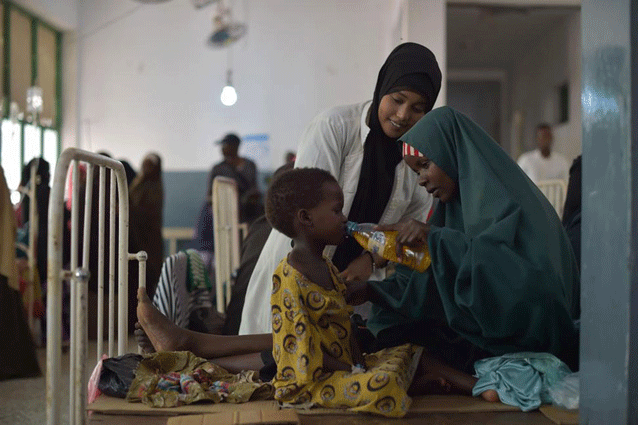 Una mujer le da a su hija una bebida con sales rehidratantes en un hospital en Mogadiscio, Somalia. Ese país sufre una grave sequía y la ONU redobló la respuesta humanitaria para evitar que empeore la situación (marzo de 2017). Crédito: Tobin Jones/UN Photo