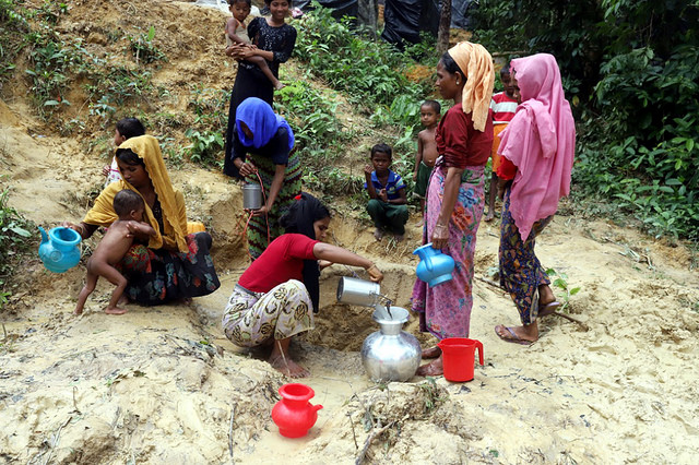 Rohinyás recogen agua de un pequeño pozo en Bangladesh. Crédit: IPS.