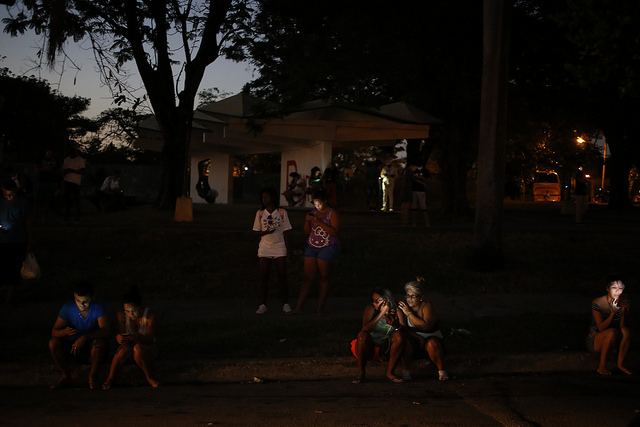 Las luces de los teléfonos móviles iluminan a las personas congregadas en un parque durante la noche, para acceder a Internet mediante la conexión inalámbrica, en uno de los llamados “puntos wifi”, en el céntrico barrio de Vedado, en la capital cubana. Crédito: Jorge Luis Baños/IPS
