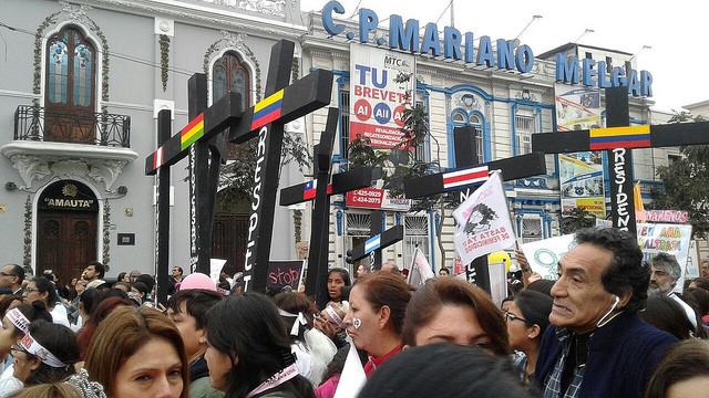 Manifestantes con cruces negras, simbolizando las víctimas de feminicidio en Perú y otros países latinoamericanos, pasan por una calle del centro de Lima, durante la multitudinaria marcha celebrada en agosto de 2015 bajo la consigna “Ni Una Menos”. Crédito: Noemí Melgarejo/IPS