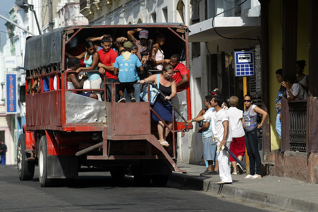 Pasajeros descienden de un camión de propiedad privada que presta servicio de transporte, en la oriental provincia de Santiago de Cuba. Crédito: Jorge Luis Baños/IPS