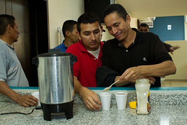 Durante su estancia en el Centro de Atención al Migrante, una oficina gubernamental al este de San Salvador, las personas deportadas pueden relajarse un poco y beber café, en medio de la camaradería que establecieron durante las horas de vuelo o desde antes, si coincidieron en centros de retención de migrantes antes del viaje. Crédito: Edgardo Ayala/IPS