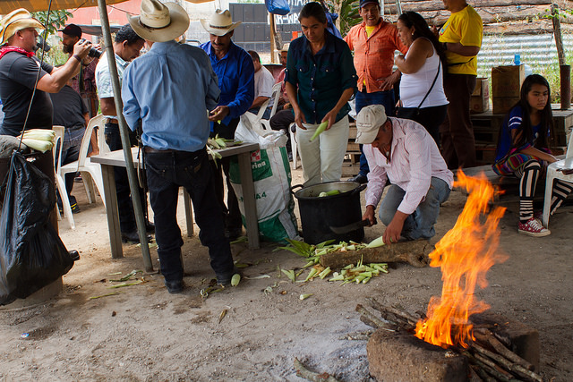 Pobladores del municipio de Casillas, en el departamento de Santa Rosa, en Guatemala, mantienen un bloqueo de la carretera que conduce a la mina de San Rafael Las Flores, para impedir el paso de suministros hacia el yacimiento. En la imagen, Rosa Dávila, en el centro, mientras pela mazorcas de maíz en el campamento improvisado de los activistas. Crédito: Edgardo Ayala/IPS