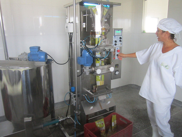Girlene Oliveira, directora comercial de la Cooperativa Ser do Sertão, controla la máquina envasadora de pulpa de fruta, con capacidad para llenar mil envases de un litro por hora, subutilizada por la limitación en las ventas y en el almacenaje de frutas congeladas. Pero aun así la iniciativa es un éxito para agricultores familiares de Pintadas, en Bahia, en la semiárida región del Nordeste de Brasil. Crédito: Mario Osava/IPS