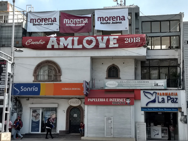 Por vez primera en la historia del país, la izquierda mexicana está a un tris de llegar a la presidencia en las elecciones de este domingo 1 de julio. En la imagen, publicidad a favor del candidato favorito, Andrés López Obrador, conocido por la sigla AMLO, en un pequeño edificio en el sur de Ciudad de México. Crédito: Emilio Godoy/IPS