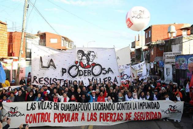 Activistas de La Poderosa, en la avenida Iriarte, la principal de la Villa 21 de Buenos Aires, el 1 de junio, al partir hacia el Palacio de Tribunales para seguir un juicio contra seis miembros de fuerzas de seguridad por denunciadas torturas contra dos adolescentes de este asentamiento popular. Crédito: Cortesía de La Garganta Poderosa