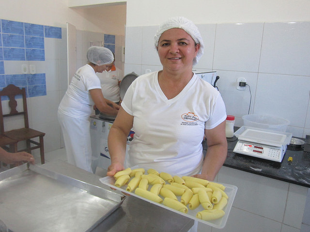 Glauciene Freire, presidenta de la asociación que opera la Panadería Comunitaria, lleva una bandeja de pasteles al horno. Ella es agrónoma con maestría en sistemas agroindustriales, la primera de una docena de campesinas ya graduadas en la universidad o estudiando ella. Crédito: Mario Osava/IPS