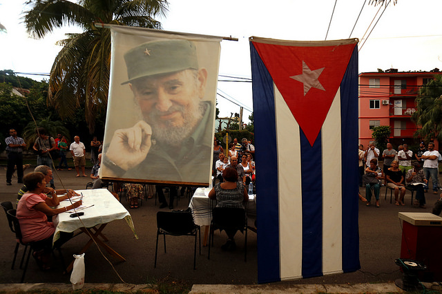 La bandera de Cuba y la imagen del fallecido líder Fidel Castro, quien gobernó el país entre 1959 y 2006, decoran una calle donde un grupo de personas participa en un debate en el barrio de Kholy, en La Habana, sobre el proyecto de Constitución se prevé que entre en vigor en 2019. Crédito: Jorge Luis Baños/IPS
