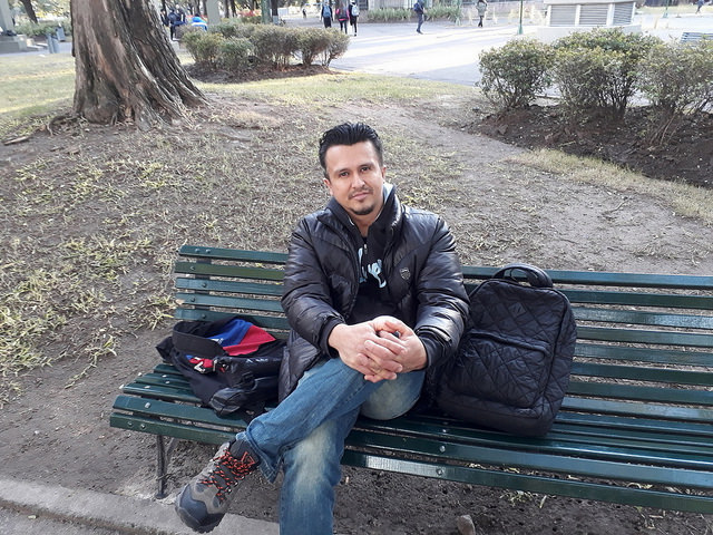 El venezolano Gerson Sánchez, en una plaza de Buenos Aires, ciudad que ya adoptó como propia. Es ingeniero agrónomo y lleva cerca de dos años en Argentina, pero como no consiguió trabajo de su profesión se gana la vida como cocinero en un restaurante del barrio de Parque Patricios. Crédito: Daniel Gutman/IPS
