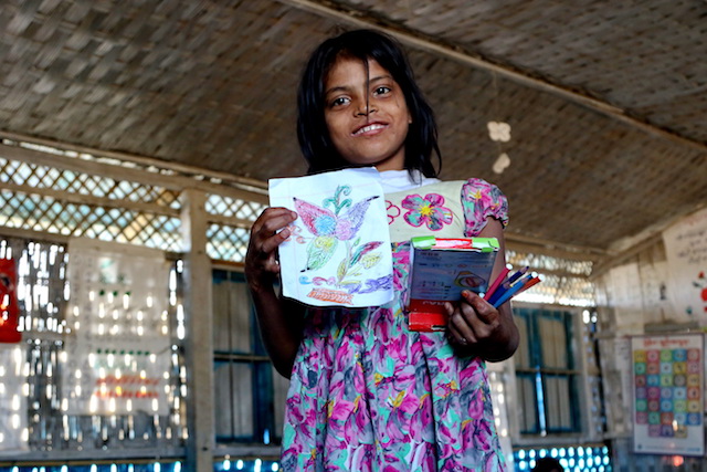 Una niña rohinyá muestra orgullosa su dibujo en una escuela de Unicef, en el campamento de refugiados de Balukhali, en Bangladesh. Crédito: Farid Ahmed/IPS