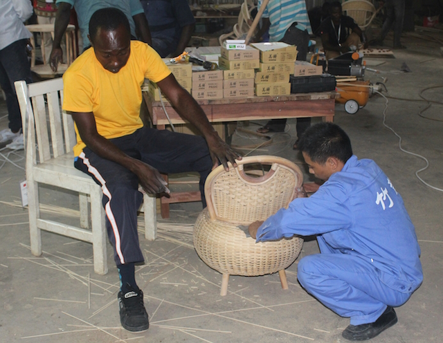 Yaw Owiredu Mintah le da los toques finales a una silla de bambú y ratán, asesorado por su profesor. Crédito: Jamila Akweley Okertchiri/IPS.
