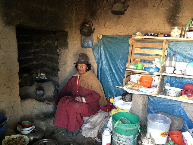 Maruja Anco, de 48 años, dentro de su actual vivienda en la aldea altoandina peruana de Quinsalakaya, donde su cocina carece de ducto para liberar el humo, que al esparcirse por el interior afecta la salud de la familia. Ella integra una de las 30 familias que están por mudarse a una vivienda que la reparará del frío de las heladas y del humo. Crédito: Annie Solís/IPS