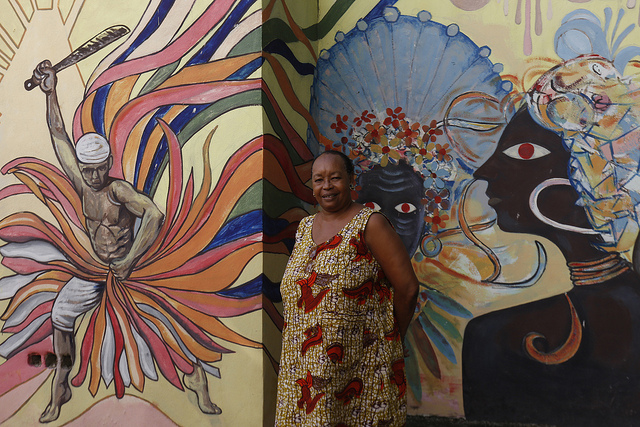 Marta E. Cordiés, directora del estatal Centro Cultural Africano Fernando Ortiz, frente a uno de los murales que decoran el patio de la institución, en la ciudad de Santiago de Cuba, en la provincia del mismo nombre, en el este de la isla caribeña. Crédito: Jorge Luis Baños/IPS