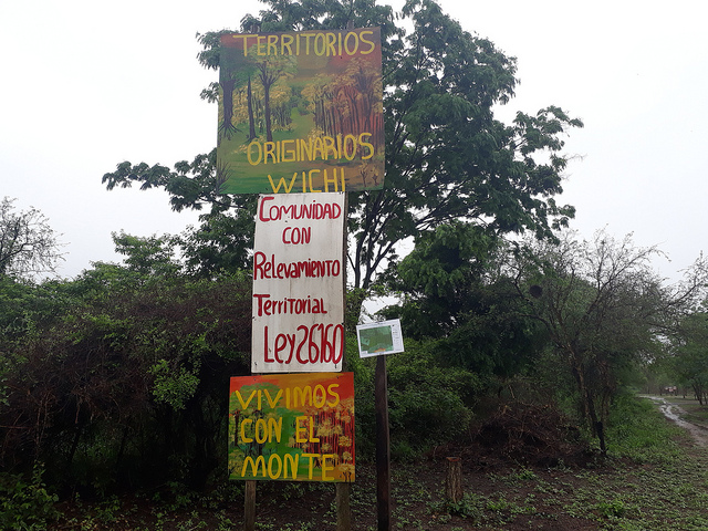 Carteles en el ingreso a una comunidad indígena de la provincia de Salta resaltan que el Estado ya efectuó el relevamiento de esas tierras y las reconoció como ancestralmente ocupadas por pobladores originarios. Pero no se ha avanzado en la titulación de la propiedad comunitaria en esta zona del norte de Argentina. Crédito: Daniel Gutman/IPS