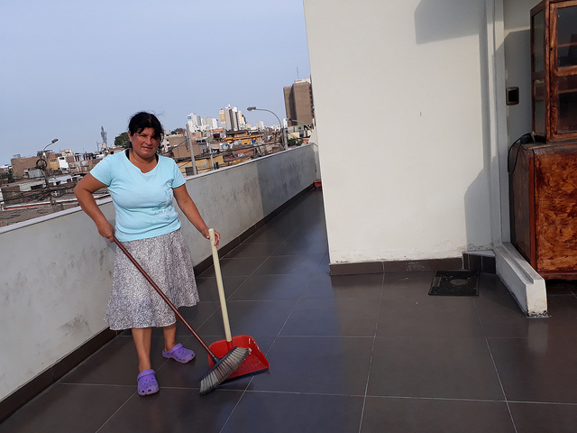 Blanca García, de 50 años, barre la terraza de un hogar de clase media de Lima. Ella trabaja como empleada del servicio doméstico por días, en varios hogares de la capital de Perú. Su principal motivación es asegurar a su hija de 14 años una buena educación, que le permita un futuro laboral con plenos derechos y oportunidades. Crédito: Mariela Jara/IPS