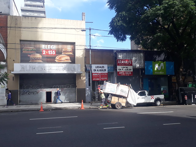 La popular avenida Corrientes, en el centro de Buenos Aires, muestra una gran cantidad de locales comerciales cerrados y que se ofrecen en alquiler, síntoma de la reducción de la actividad económica en Argentina. En primer plano, el carro de un cartonero, el nombre local para quienes buscan en la basura objetos con algún valor. Crédito: Daniel Gutman/IPS