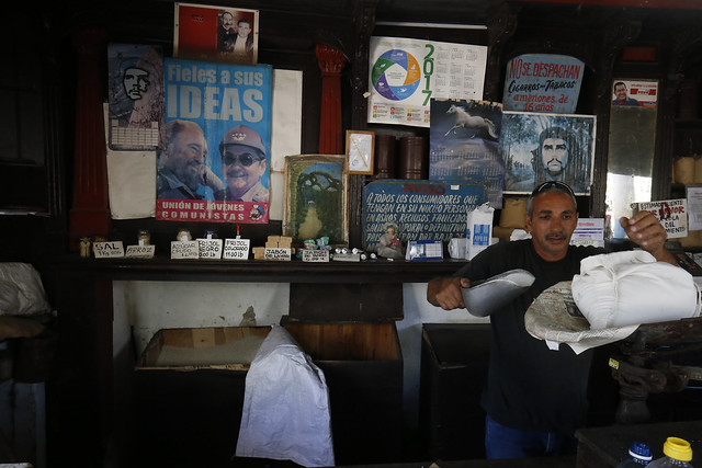 Un empleado expende productos subsidiados en el interior de un establecimiento estatal, decorado con imágenes alegóricas a la revolución cubana, en el barrio del Vedado, en La Habana. La escasez de alimentos preocupa a la población cubana, ante el empeoramiento de la crisis económica. Crédito: Jorge Luis Baños/IPS