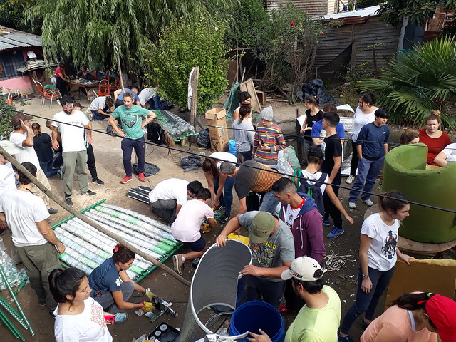 Jóvenes voluntarios de Sumando Energías trabajan en la construcción de los colectores solares en el barrio de Pinazo. La oeenegé los adiestra en el desarrollo de energías limpias que aporten soluciones sociales, ambientales y económicas en entornos vulnerables de Argentina. Crédito: Daniel Gutman/IPS