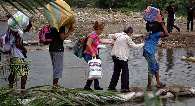 Un grupo familiar cruza el río Táchira, para ingresar desde Venezuela a Colombia. Crédito: Tomer Urwicz/UNFPA