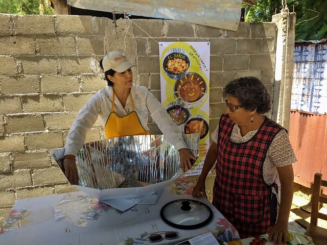 Lorena Harp (I), responsable de promover las cocinas solares en México, muestra cómo armar el dispositivo a la maestra jubilada Irma Jiménez, en el barrio popular de Vicente Guerrero, en el municipio de Villa de Zaachila, en el sureño estado de Oaxaca. Crédito: Emilio Godoy/IPS