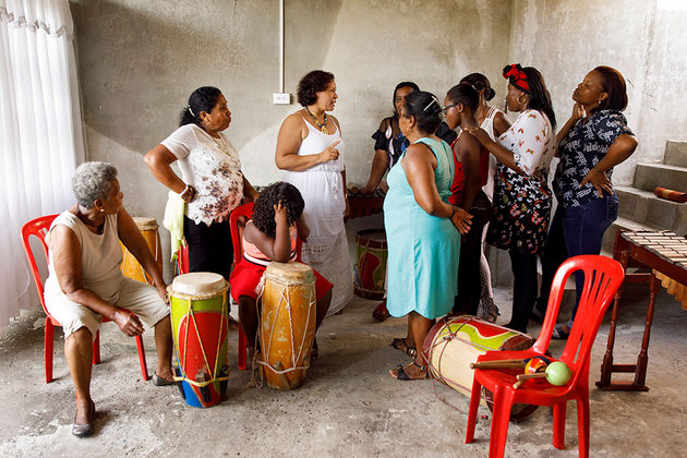 Paola Andrea Navia Cassanova, al centro (de blanco), organiza una reunión de ensayo del grupo intergeneracional Cantadoras en Tumaco. Crédito: Ryan Brown/ONU Mujeres