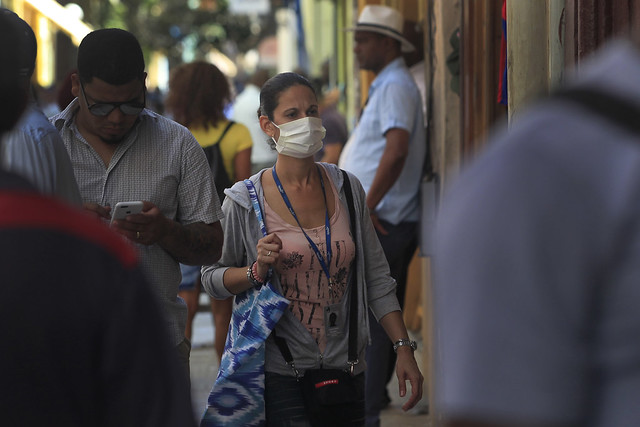 Una mujer camina por una calle del casco histórico de La Habana con una mascarilla protectora para prevenir el contagio del coranovirus. Foto: Jorge Luis Baños/IPS