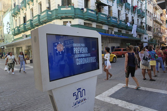 Una pantalla colocada en un céntrico boulevard de La Habana transmite mensajes informativos para la prevención del coronavirus entre la población cubana, que tiene una franja de adultos mayores de 2,2 millones de personas. Foto: Jorge Luis Baños/IPS