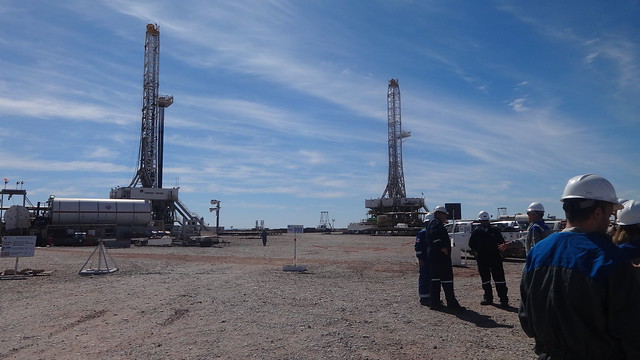 Unos técnicos dialogan cerca de dos torres de perforación en el yacimiento de petróleo y gas no convencional de Loma Campana, en Vaca Muerta, en Argentina. Foto: Fabiana Frayssinet/IPS