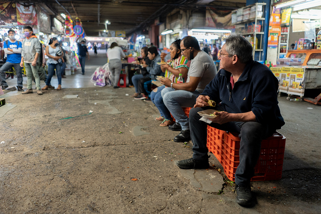 Las taquerías dentro del mercado solo están vendiendo comida para llevar, pero los clientes comen frente a los negocios. Foto: María Ruiz/Pie de Página
